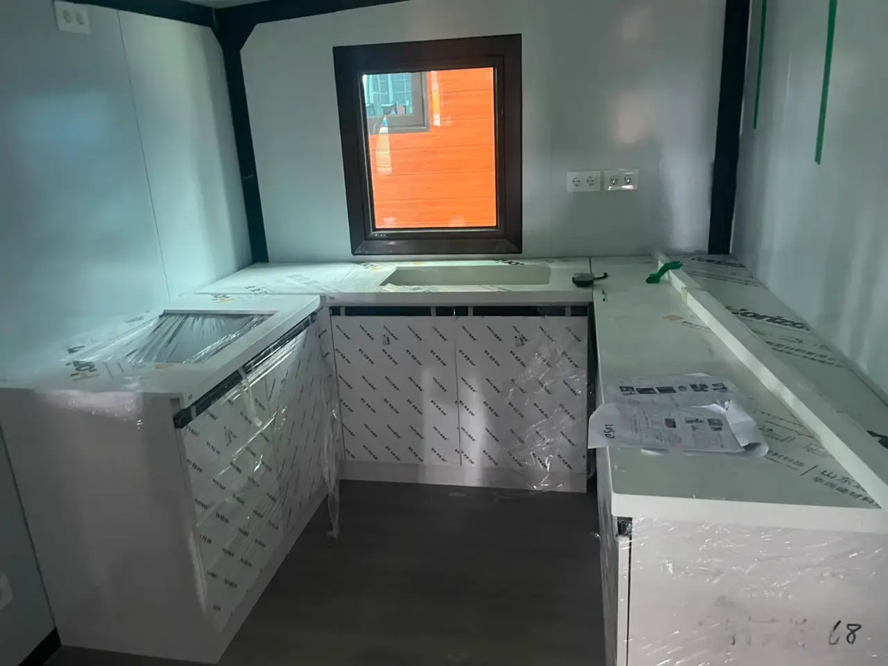 Compact U-shaped modular kitchen with wrapped cabinets and countertops