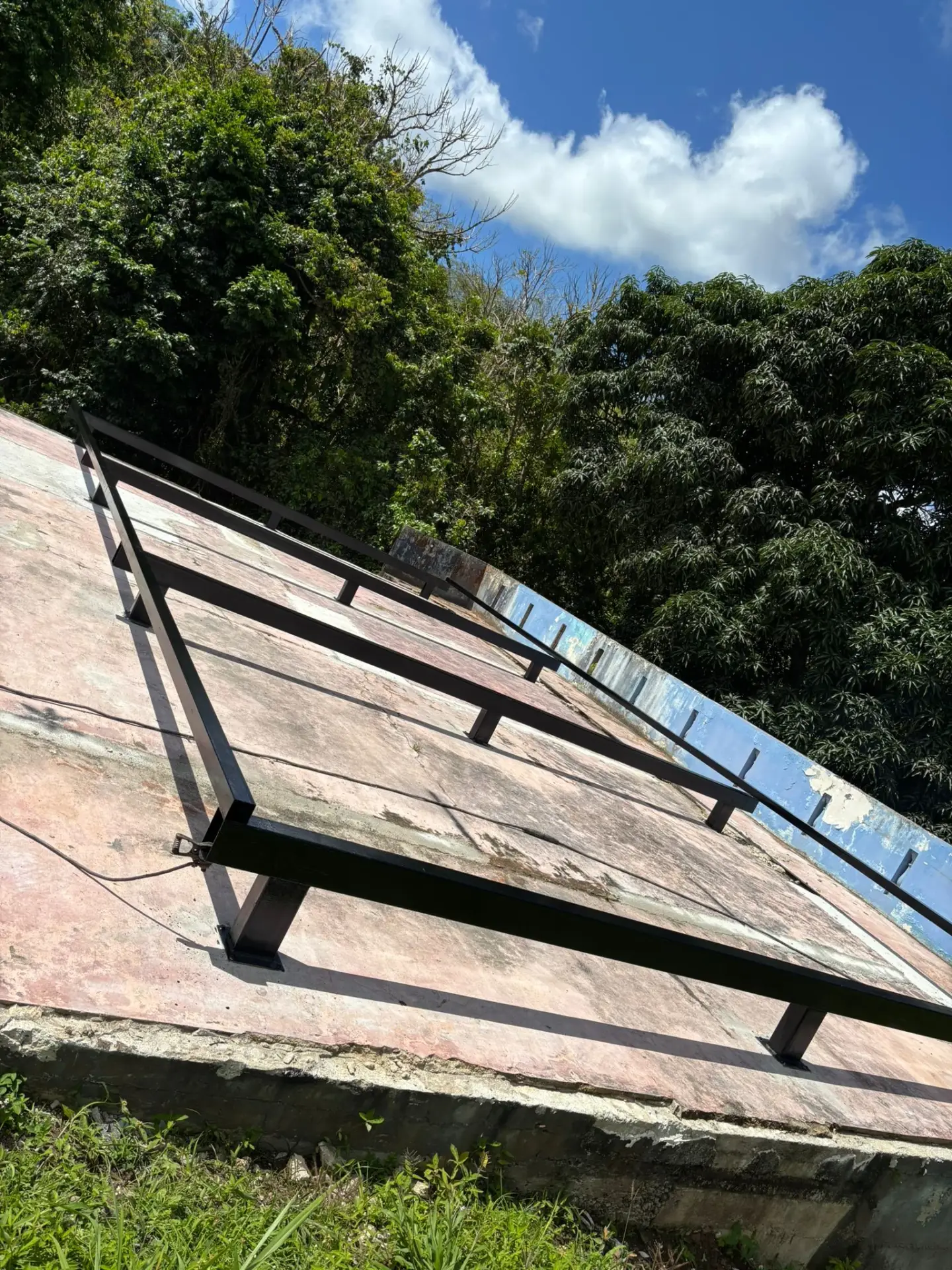 Black steel foundation frame welded to an elevated concrete slab on a tropical site