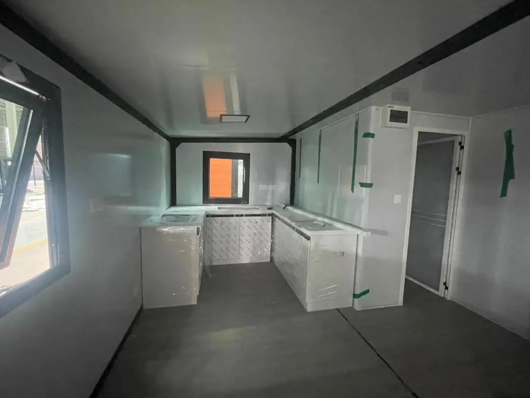 Compact white kitchen inside a modular home during interior finishing