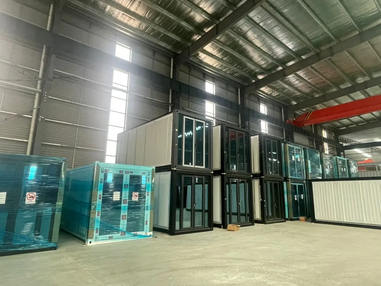 Wrapped and stacked modular building units inside a manufacturing warehouse