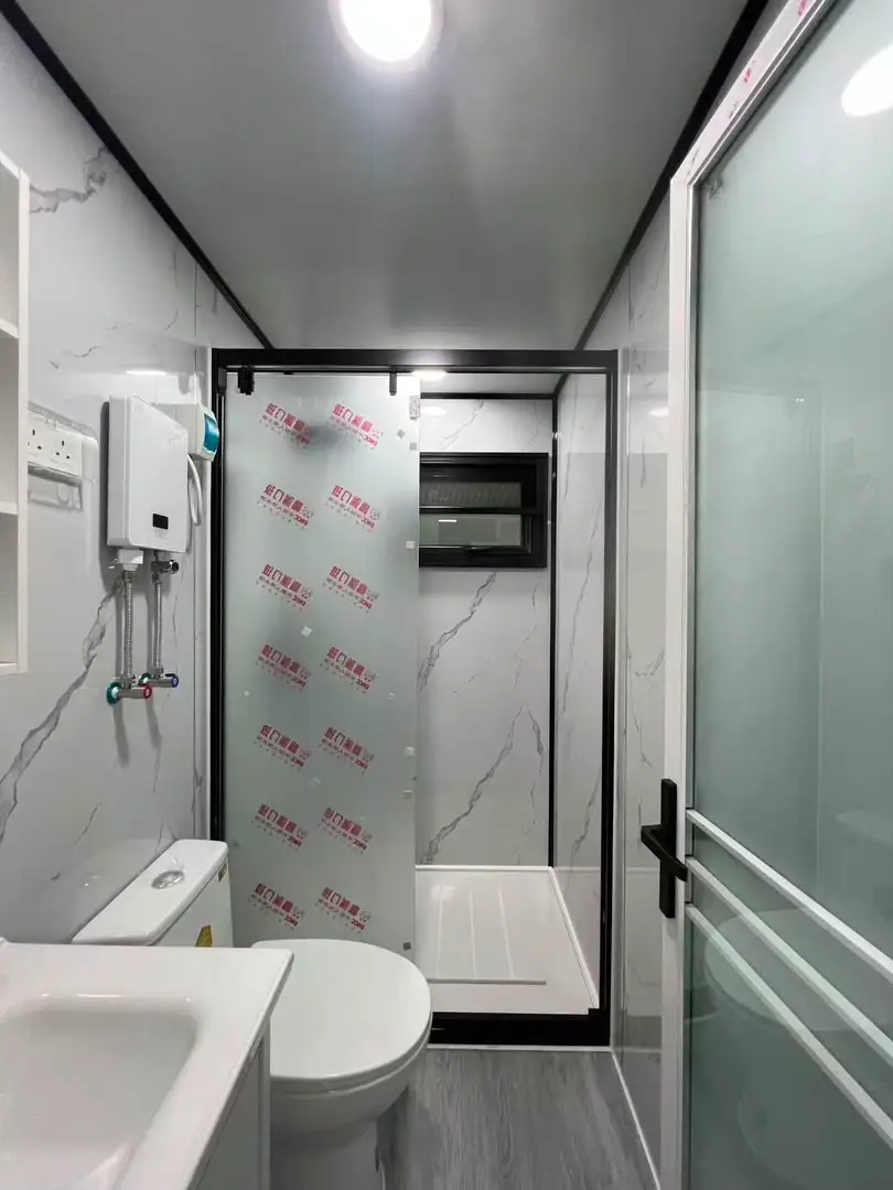 Compact modular bathroom with a vanity, toilet, and walk-in shower enclosure
